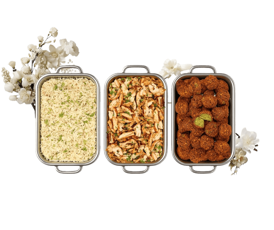 Professional Greek catering trays with rice pilaf, grilled chicken, and golden falafel with decorative flowers - Toronto catering delivery