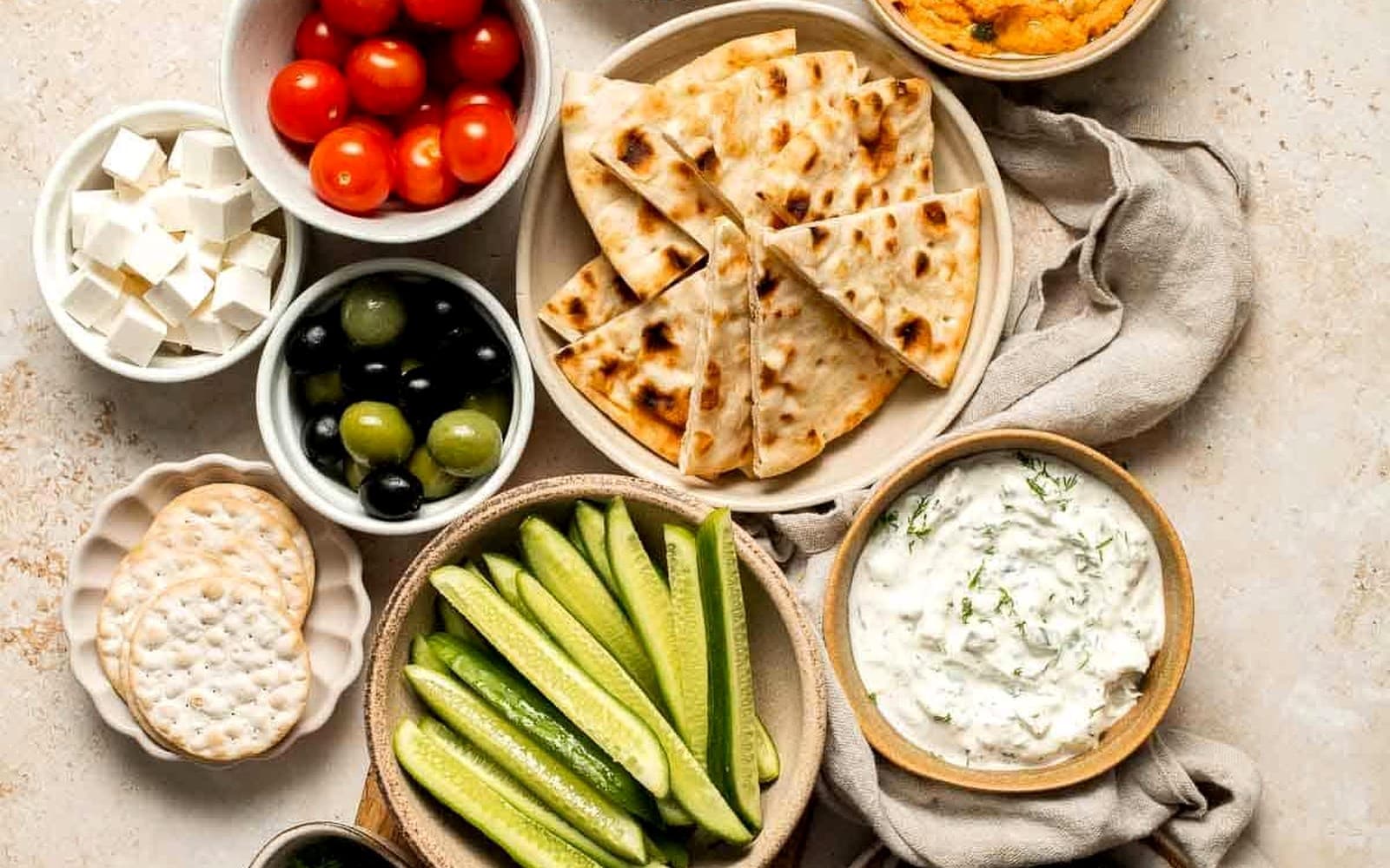 Premium Mediterranean mezze with hummus, tzatziki, cucumber, flatbread, and dolmades