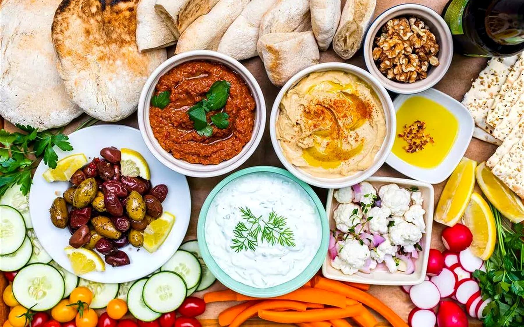 Premium Greek mezze board with dips, pita, olives, vegetables, and tzatziki