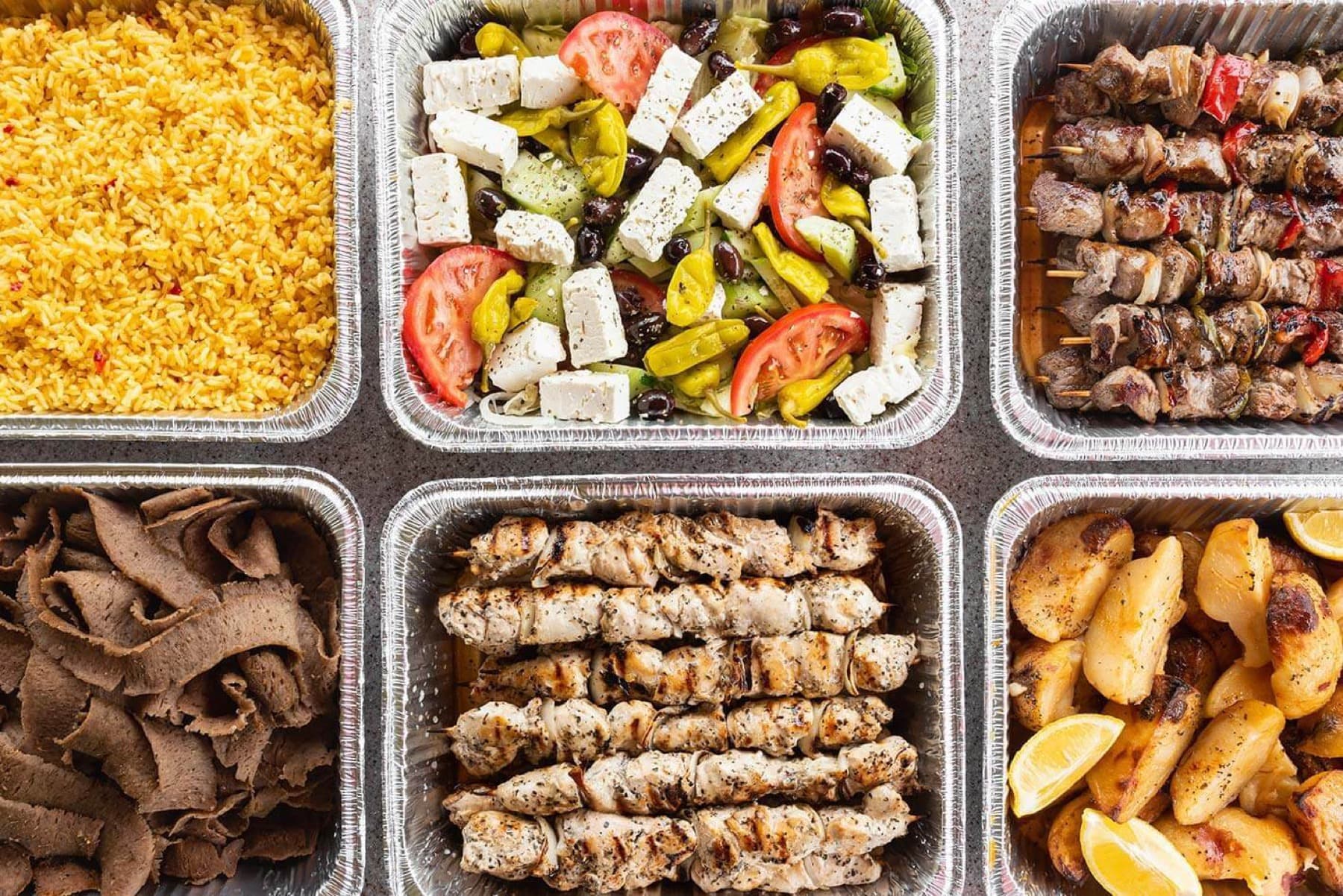 Gyro Bar service trays with toppings, chicken, gyro meat, salads, and sides
