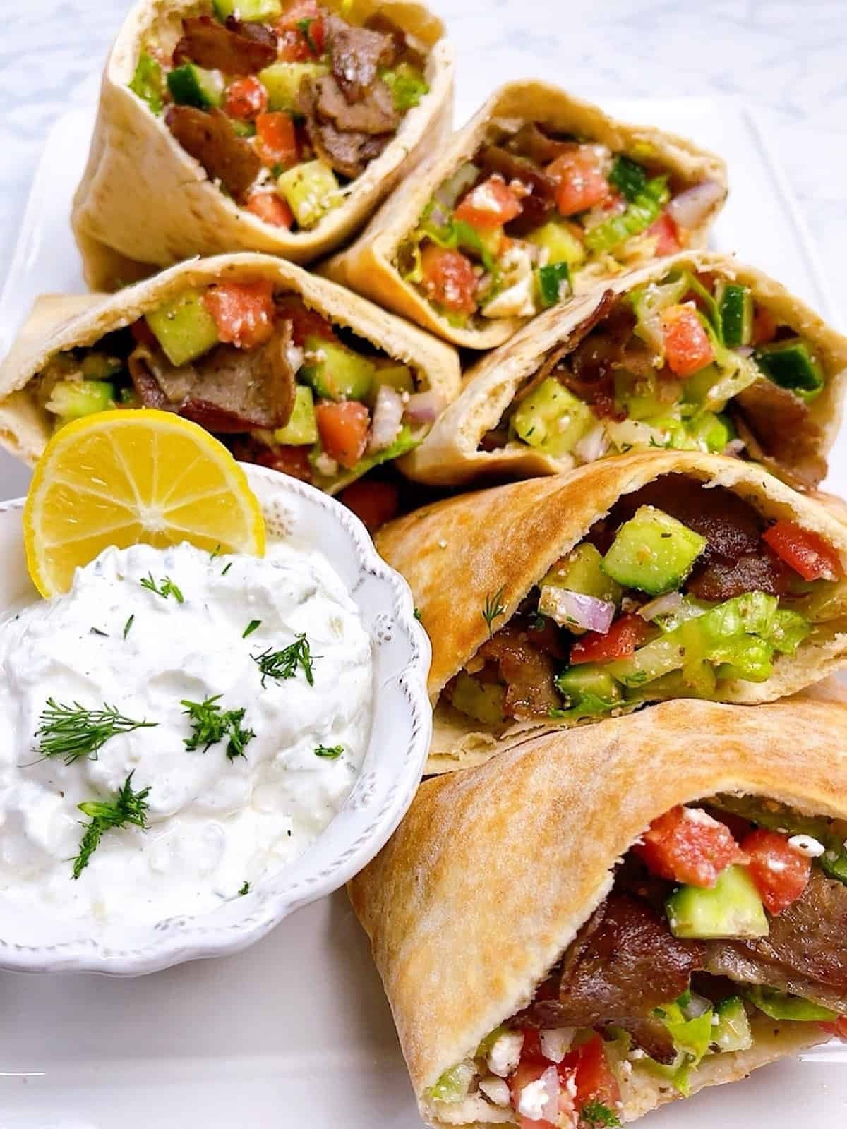 Greek pita pockets filled with gyro, vegetables, and tzatziki